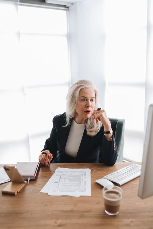 A charity trustee reviewing board papers at her desk